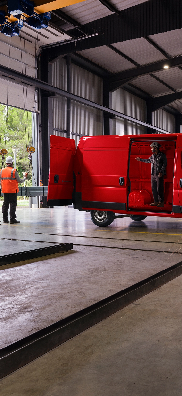 Seitenansicht eines roten Citroën Jumper in einer Werkstattumgebung, die das robuste Außendesign und die professionelle Nutzbarkeit hervorhebt.