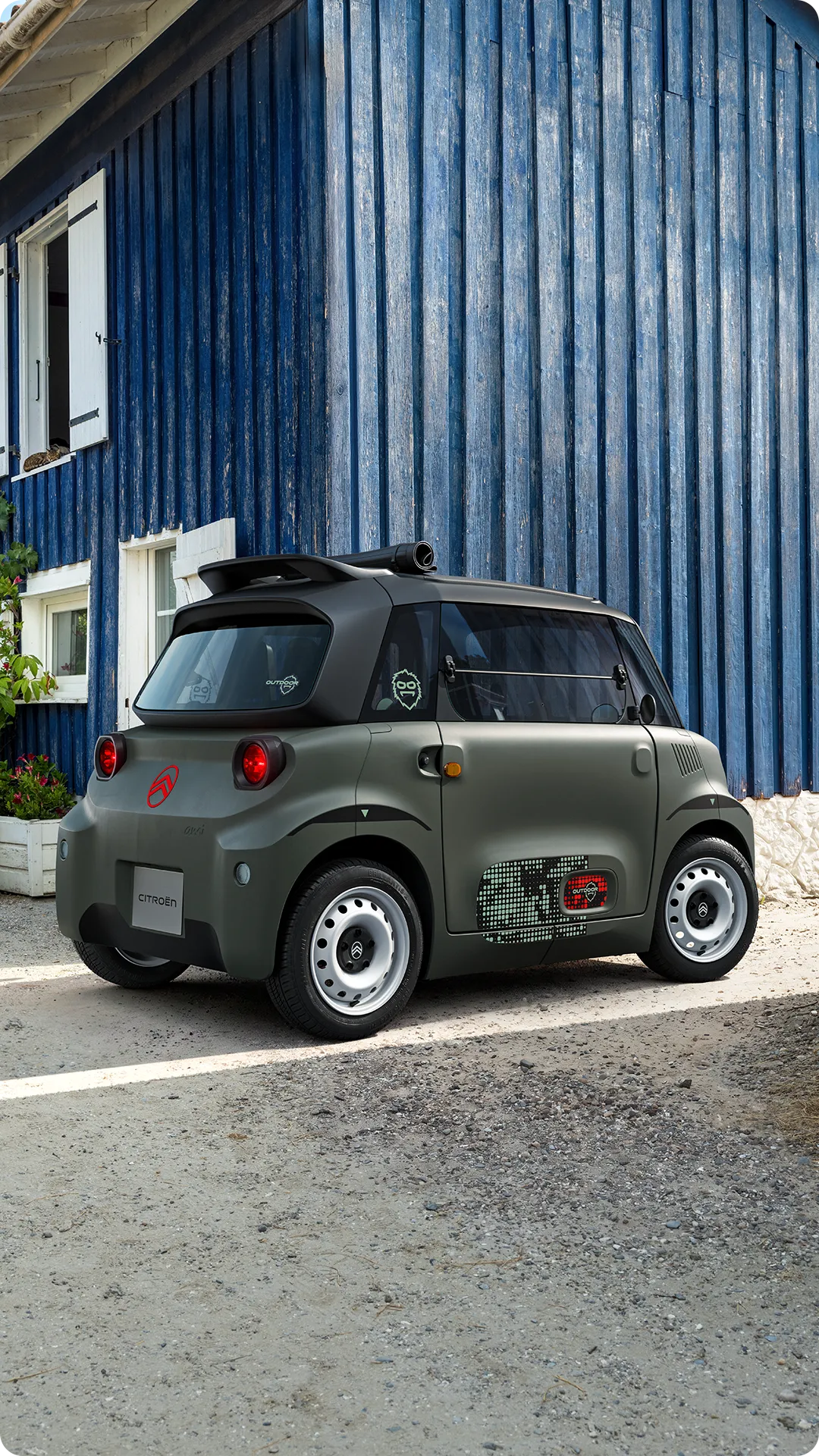 Frontansicht des Citroën Ami Outdoor mit LED-Scheinwerfern zeigt das ultrakompakte elektrische Stadtfahrzeug auf einer schmalen Straße