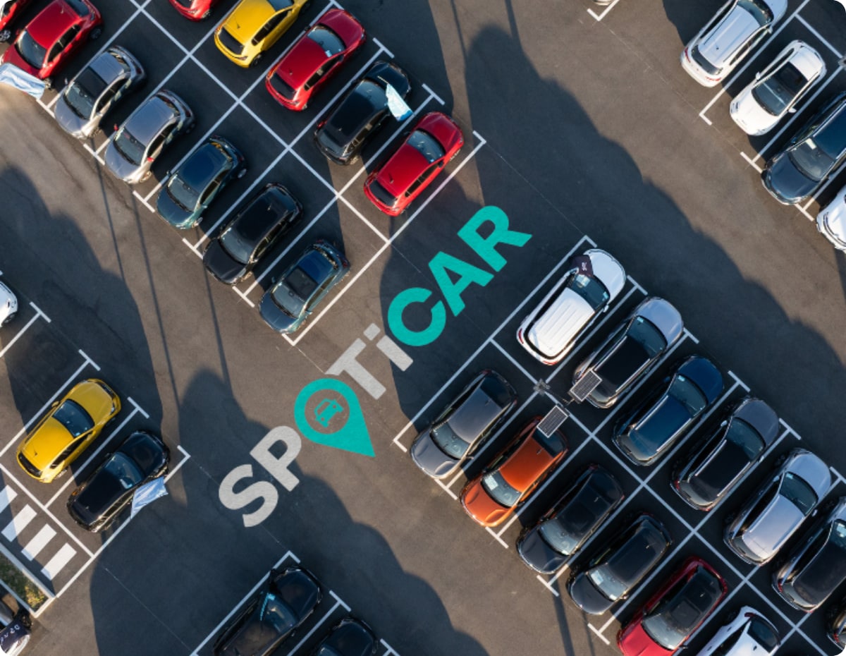 Luftaufnahme eines Parkplatzes mit mehreren Fahrzeugen und Spoticar-Branding, die geprüfte Citroën Gebrauchtwagen und Verfügbarkeit hervorhebt.