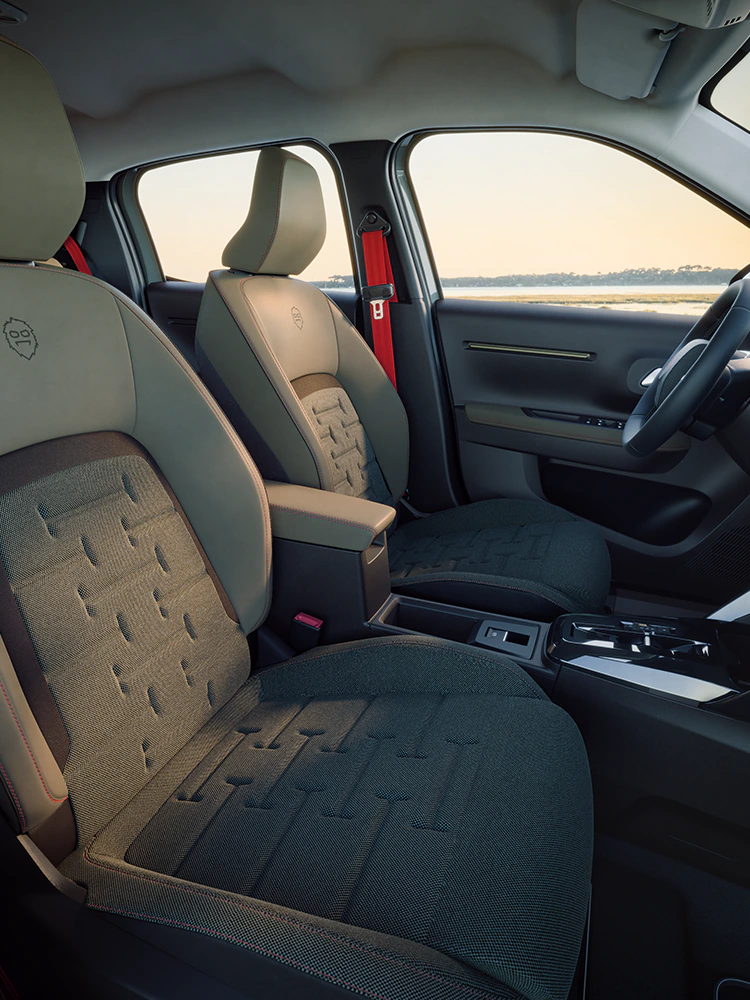 Frontansicht des Innenraums des Citroën ë-C3 Outdoor zeigt Advanced Comfort Sitze und eine geräumige Kabine für Familienreisen im kompakten SUV
