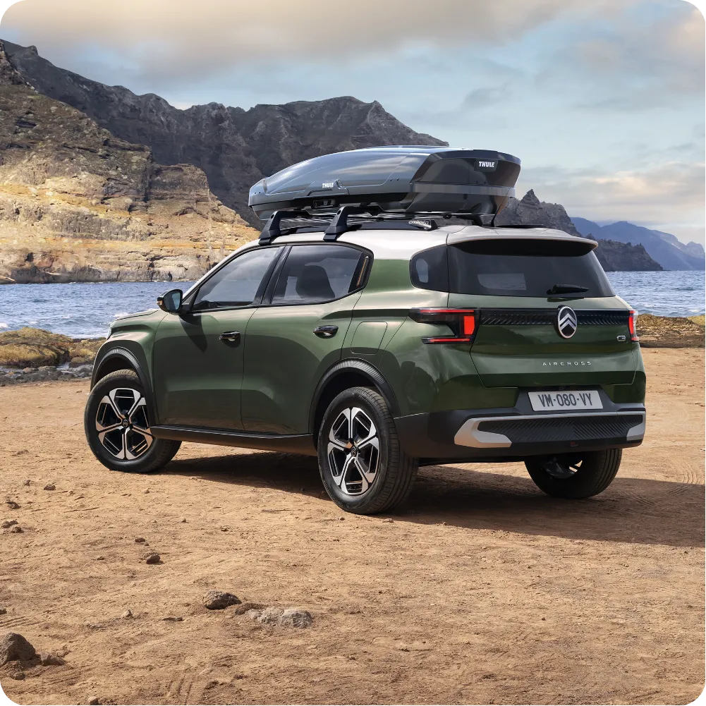 Outdoor view of Citroën ë‑C3 Aircross electric SUV with roof bars and roof box for versatile, spacious and affordable travel capability.