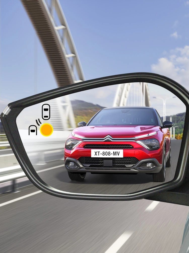 Totwinkelwarnung im Spiegel des Citroën C4 X zeigt ein sich von hinten näherndes Fahrzeug