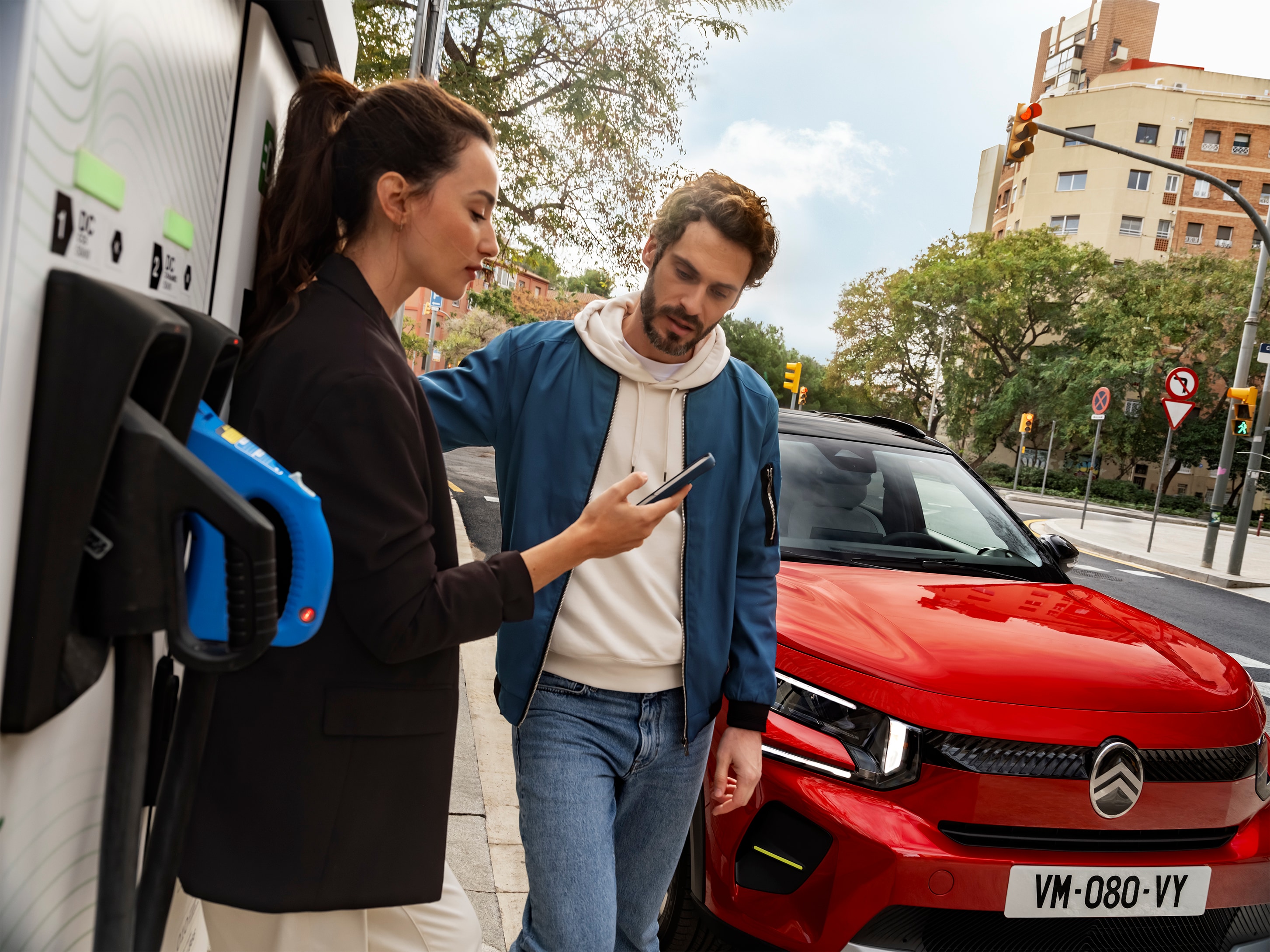 Straßenladeansicht des Citroën C3 SUV mit Personen, die das Schnellladen vorbereiten, für bequeme, effiziente und erschwingliche Stadtmobilität.
