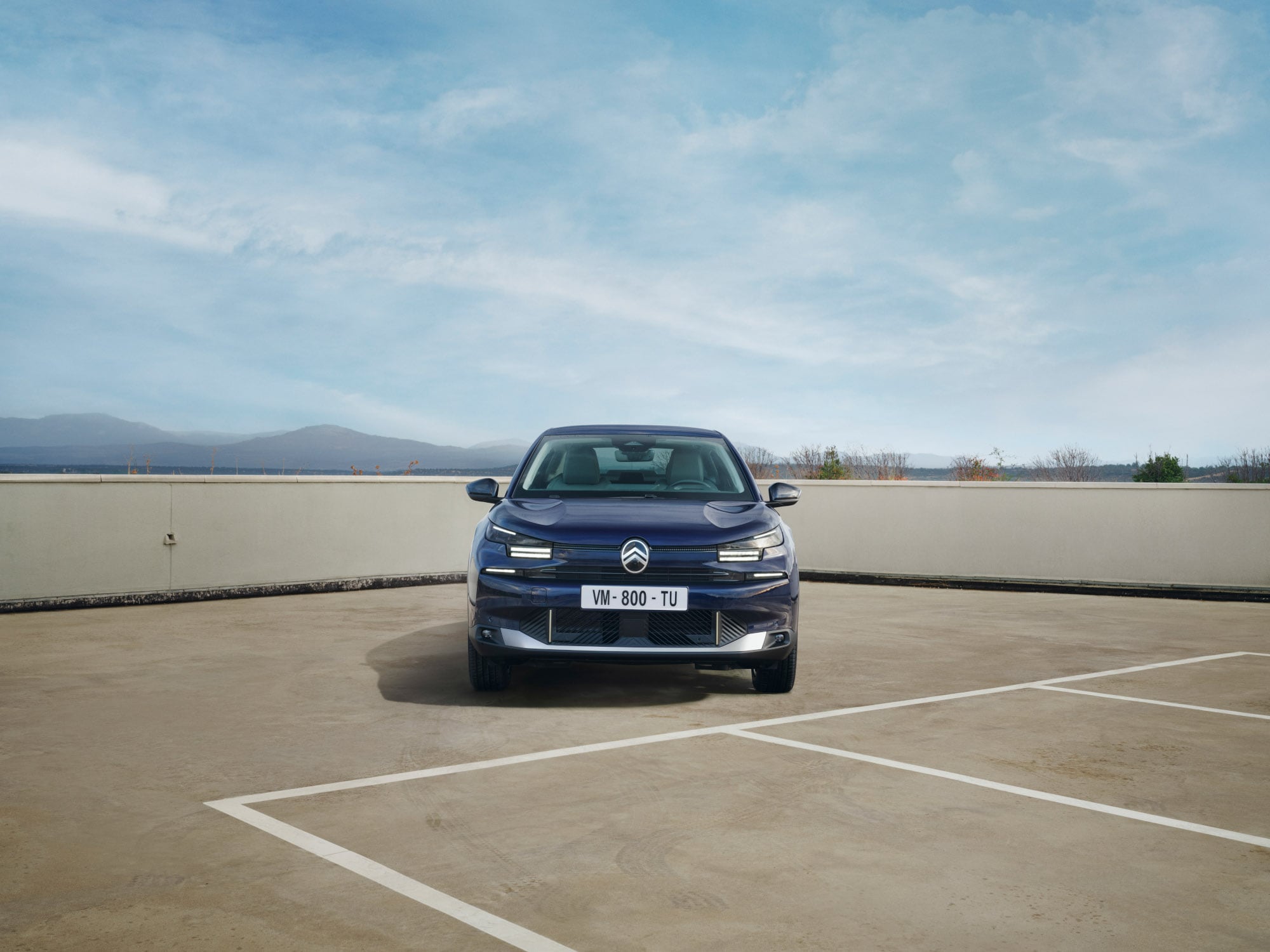 Frontansicht des Citroën C4 X auf Dachparkplatz zeigt markante Fastback-Haltung für selbstbewusste, erschwingliche Mobilität