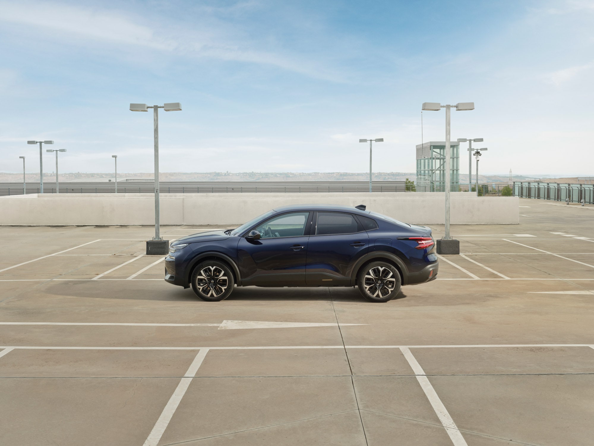 Seitenansicht des Citroën C4 X auf Dachparkplatz zeigt elegantes Fastback-Profil für effiziente, erschwingliche Mobilität