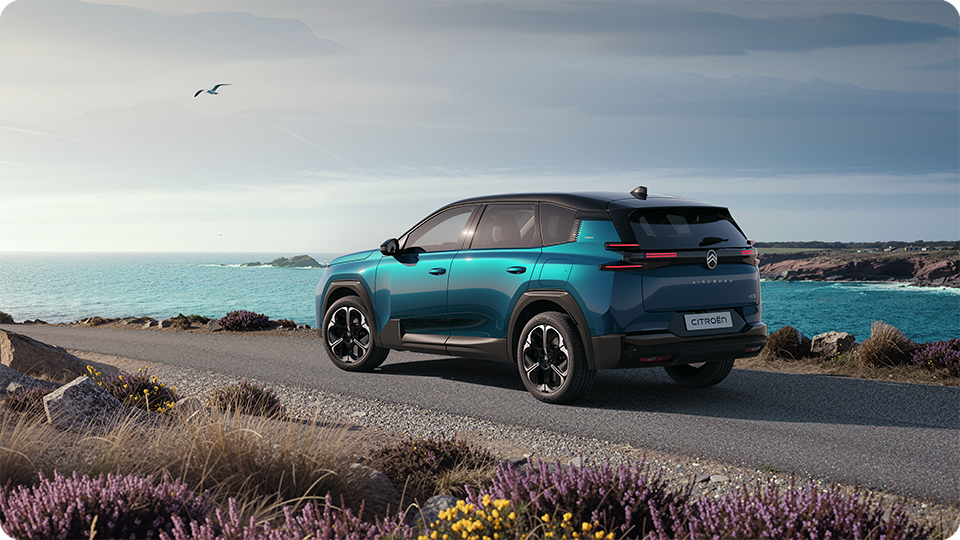Dreiviertel-Heckansicht des Citroën ë-C5 Aircross Emeraude; zeigt die Citroën Light-Wings-LED-Heckleuchten und das großzügige Design des Familien-SUV
