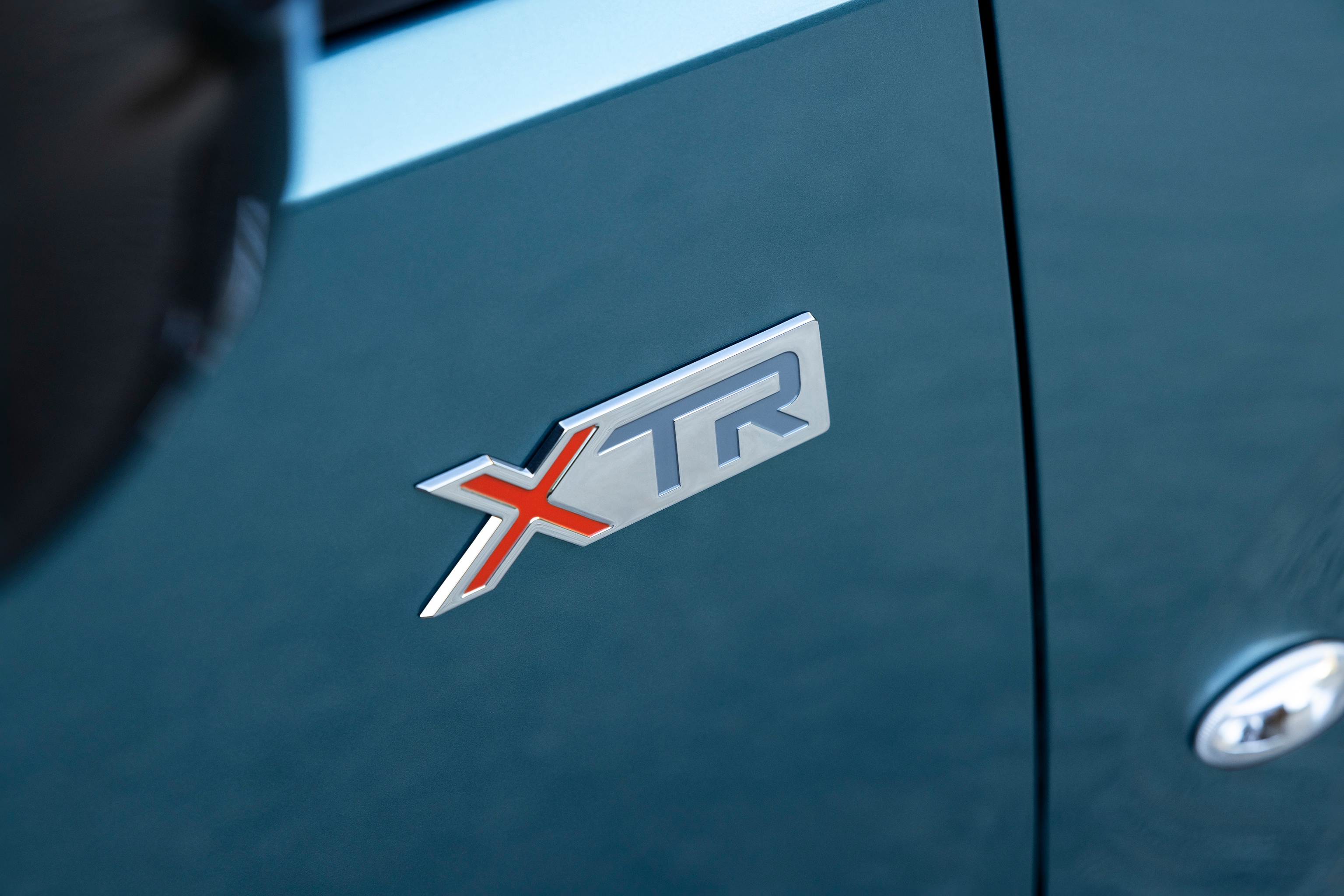 Detail view ë-Berlingo XTR badge highlighting distinctive design, quality, durability and enhanced model identity