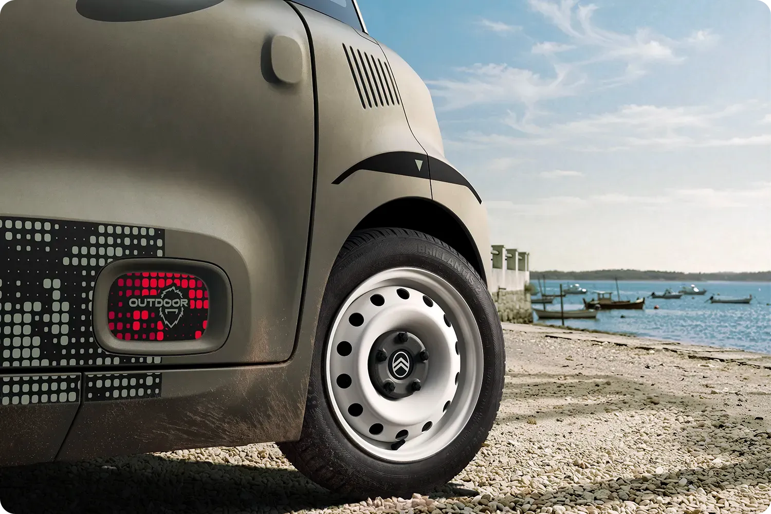 Nahaufnahme des Radlaufs des Citroën Ami Outdoor – kompaktes, elektrisches und erschwingliches Design mit innovativem Styling für Abenteuer an der Küste.